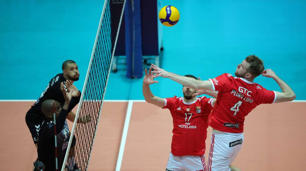 Os jogadores do Benfica, Pedro Lobo (D) e Tiago Violas, disputam um lance com o jogador do A.J. Fonte Bastardo, Eliezer Dutra (1-E), durante o jogo da final da Taça de Portugal de seniores masculinos de Voleibol, realizado no pavilhão do Centro Cultural de Viana do Castelo, 12 de março 2023. ESTELA SILVA/LUSA
