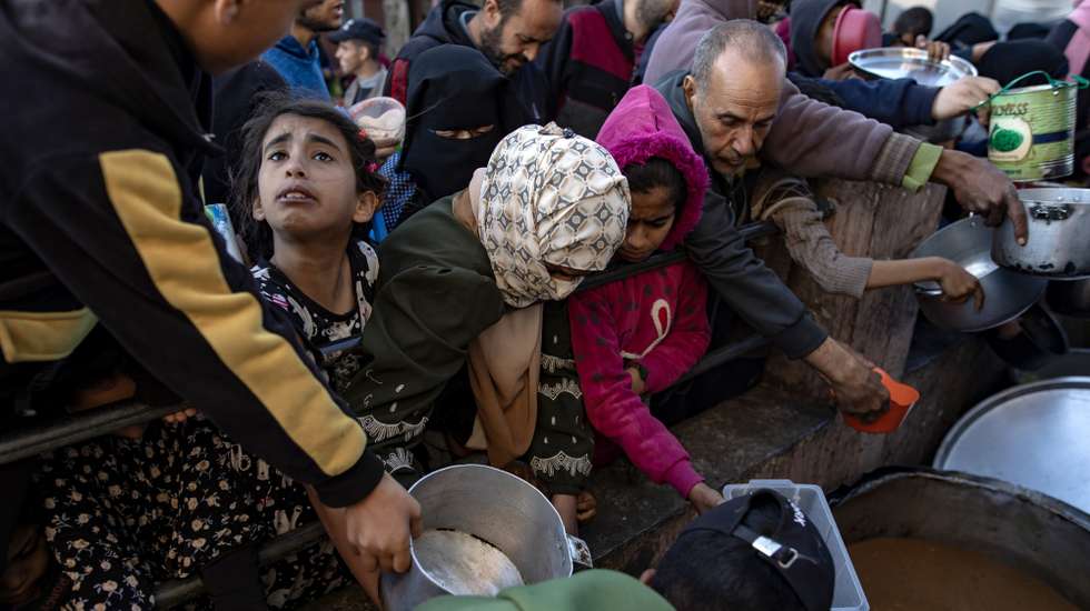 epa11239264 Internally displaced Palestinians gather to collect food donated by a charitable group before breaking the fast during the Muslim holy month of Ramadan in Rafah, southern Gaza Strip, 23 March 2024. Since 07 October 2023, up to 1.9 million people, or more than 85 percent of the population, have been displaced throughout the Gaza Strip, some more than once, according to the United Nations Relief and Works Agency for Palestine Refugees in the Near East (UNRWA), which added that most civilians in Gaza are in 'desperate need of humanitarian assistance and protection'.  EPA/HAITHAM IMAD