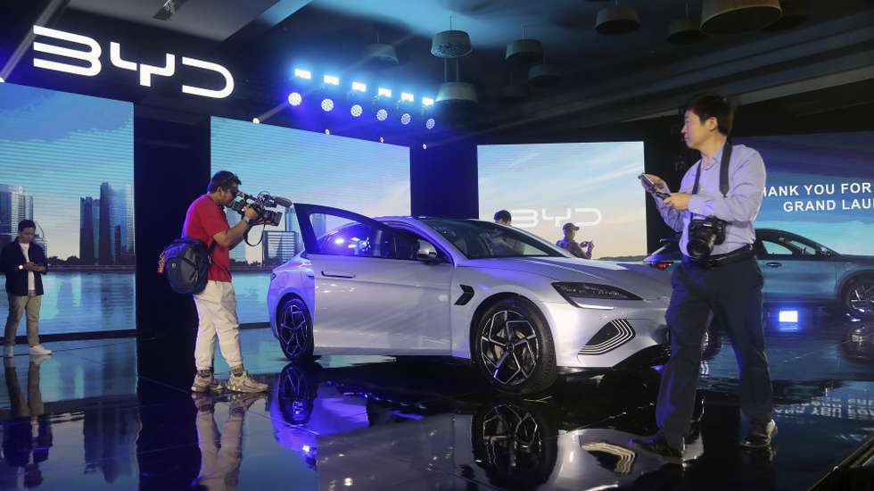 epa11086527 Journalists stand around a Build Your Dreams (BYD) Seal model during a launching ceremony of New Energy Vehicles (NEV) in Jakarta, Indonesia, 18 January 2024. BYD launched three NEVs Models: the BYD Seal, BYD Atto 3 and BYD Dolphin.  EPA/BAGUS INDAHONO
