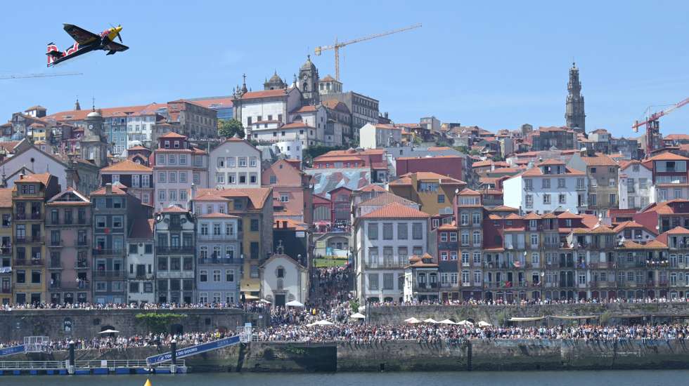 Um avião faz acrobacias durante o festival aéreo Air Invictus, que decorreu no rio Douro entre as margens do Porto e de Vila Nova de Gaia, 20 de junho de 2026. Os primeiros aviões do Air Invictus já abriram as hostilidades no Porto e em Gaia para um “bálsamo desejado” para os comerciantes, um “evento do caraças” para os turistas e um momento “seja o que Deus quiser” para as autoridades. FERNANDO VELUDO/LUSA