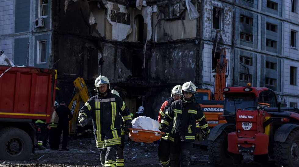epa10596759 Rescuers carry a body recovered at the site of a damaged residential building after a missile attack, in Uman, Cherkasy region, central Ukraine, 28 April 2023. At least 17 people were killed as a result of a rocket attack in Uman, and 18 others were injured, according to the State Emergency Service of Ukraine. Ukraine's Ministry of Internal Affairs said on 28 April, that the Russian army conducted attacks on residential buildings across the country, including Dnipro, Uman and Ukrainka in the Kyiv region.  EPA/OLEG PETRASYUK