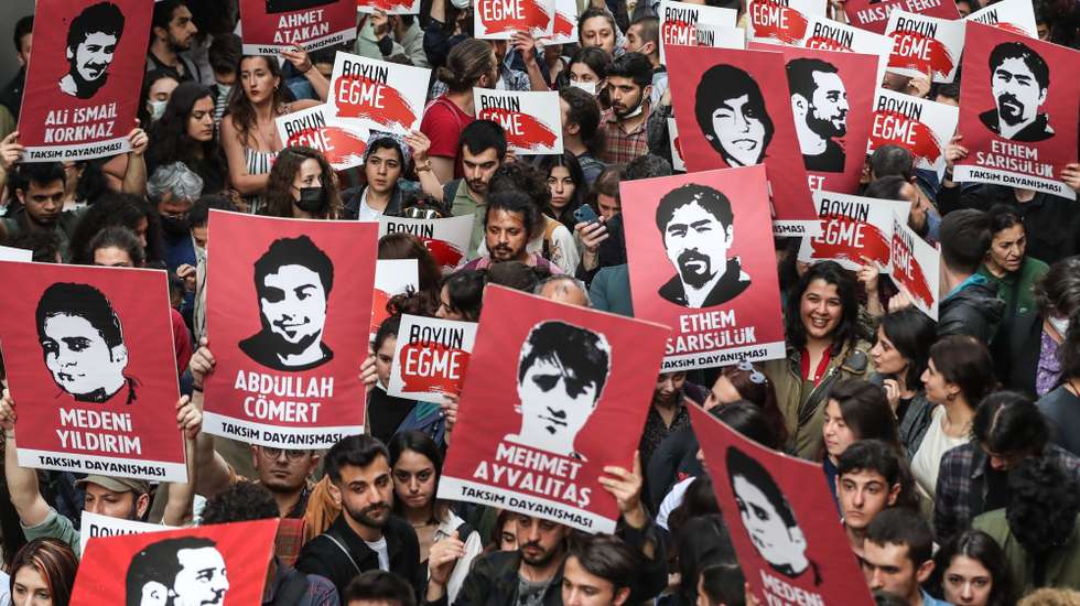 epaselect epa09910604 Protesters hold pictures of the victims of Gezi Park protest as they shouts slogans in support of the jailed Turkish businessman and philanthropist Osman Kavala, near Taksim Square in Istanbul, Turkey, 26 April 2022. A Turkish court handed civil rights activist Osman Kavala a life sentence and also sentenced seven other defendants, including 71-year-old architect Mucella Yapici, to 18 years in prison.  EPA/SEDAT SUNA