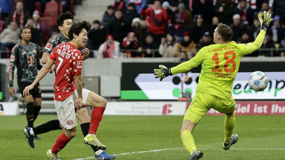 epa11776700 Jae-sung Lee of Mainz (L) scores the 1-0 lead during the German Bundesliga soccer match between 1. FSV Mainz 05 and FC Bayern Munich in Mainz, Germany, 14 December 2024.  EPA/RONALD WITTEK CONDITIONS - ATTENTION: The DFL regulations prohibit any use of photographs as image sequences and/or quasi-video.
