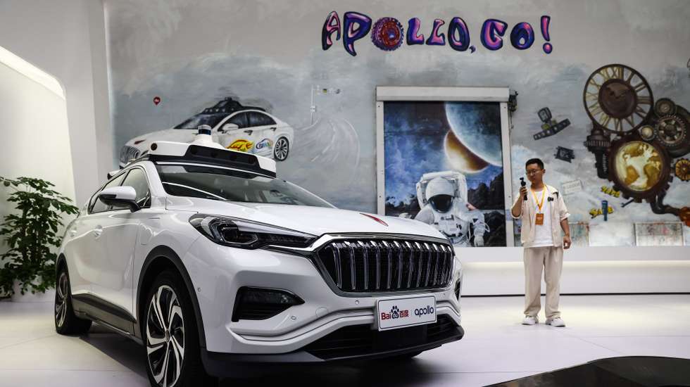 epa13015068 A visitor takes a photo of self-driving cars on display at the Baidu Apollo Park during an organized media tour in Beijing, China, 04 June 2026.  EPA/WU HAO
