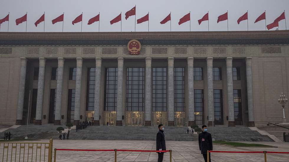 epa09053086 Security officials wearing protective face masks stand guard in front of the Great Hall of the People prior to the opening session of the National People’s Congress (NPC), in Beijing, China, 05 March 2021. China holds two major annual political meetings, The National People’s Congress (NPC) and the Chinese People's Political Consultative Conference (CPPCC) which run alongside and together known as 'Lianghui' or 'Two Sessions'.  EPA/ROMAN PILIPEY