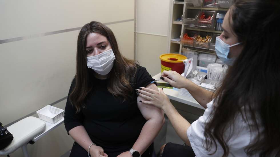 epa09421726 A nurse injects an Israeli woman with a third shot of COVID-19 vaccine in Jerusalem, 20 August 2021. Israel has started to offer a third shot of covid vaccine to people aged over 40 as a measure to stop the spreading of the Delta variant.  EPA/ATEF SAFADI