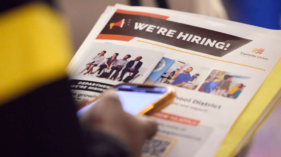 epa12037858 A person reads a hiring document from a company at a job fair in Los Angeles, California, USA, 17 April 2025. The number of people who applied for unemployment benefits last week fell by 9,000 to 215,000 and matched a two-month low, the government said today.  EPA/ALLISON DINNER