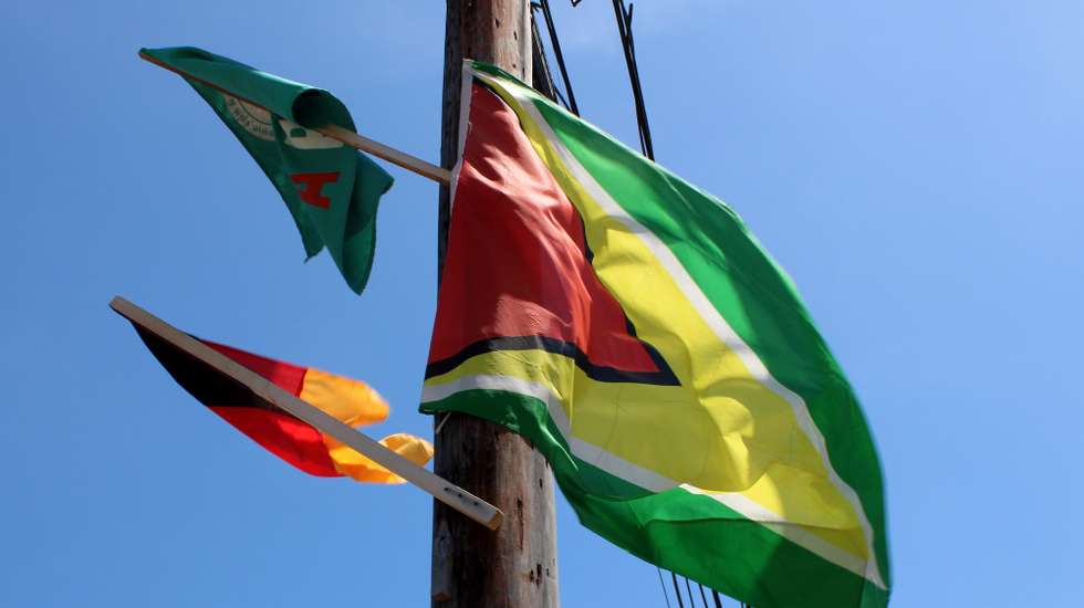 epa12347067 Photograph shows the Guyana flag alongside the flags of the main PPP/C and APNU parties in Georgetown, Guyana, 02 September 2025. Guyana counts the votes from the general election on 02 September, with the parties of President Irfaan Ali and businessman Azurddin Mohamed emerging as front runners.  EPA/NAZIMA RAGHUBIR