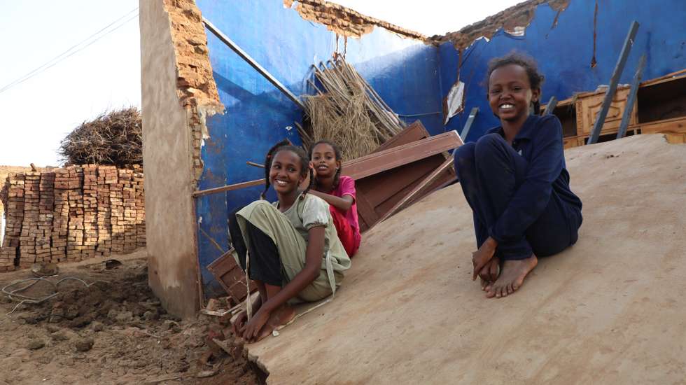 epa10135173 Sudanese children pose for photos as they sit on their destroyed house at a flooded area of Al Jazirah state, Sudan, 23 August 2022. According to the Sudanese Council for Civil Defense, at least 79 people died in incidents related to the recent floods in the country. Thousands of homes were damaged due to the floods that affected South Darfur, North Kordofan, and Al Jazirah state.  EPA/MOHND AWAD