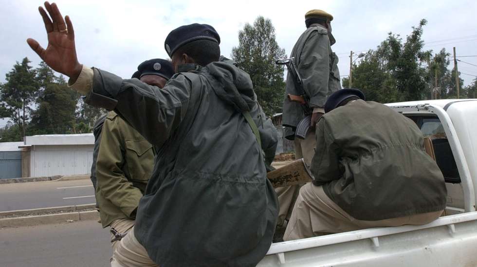 epa000454057 Ethiopian police hide from the camera and gestures for the media to quit taking pictures after a neigbourhood of Addis Ababa was closed for a security operation on Friday 10 June 2005. Most shops were shuttered and taxis were again on strike for the third day in a row while families collected the dead for burial following riots over election results and government warnings that any more civil unrest would be dealt with sternly.  EPA/STEPHEN MORRISON