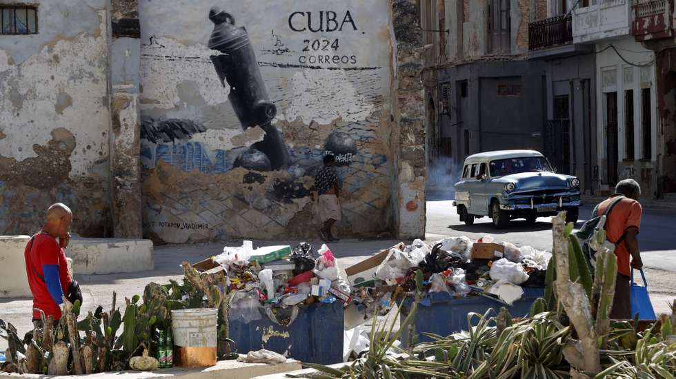 epa12849149 People walk past rubbish accumulating in the streets of Havana, Cuba, 25 March 2026. The Caribbean nation has been experiencing a severe crisis since mid-2014, which has deepened with the oil embargo imposed by the US government since January 2026. The United Nations (UN) has described the US measures as 'actions that violate human rights.'  EPA/ERNESTO MASTRASCUSA