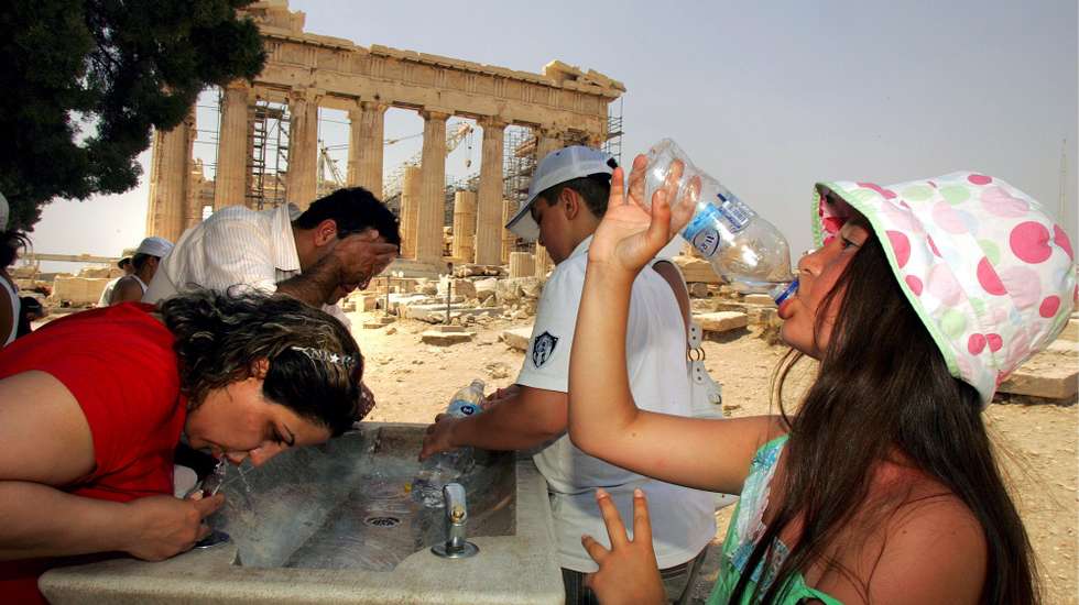 epa01075714 Tourists visiting Acropolis in Athens refresh themselves under the hot sun, 24 July 2007. Temperatures in Athens climbed up to 43 degrees Celsius as Greece is hit by a heat wave.  EPA/SIMELA PANTZARTZI