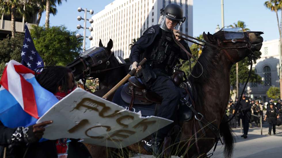epa12170851 Los Angeles Police Department officers clash with protesters outsside of Los Angeles City Hall in Los Angeles, California, USA, 11 June 2025. US President Donald Trump has deployed 2,000 National Guard troops, despite not receiving a request from the state of California for any additional assistance, following large protests against ongoing immigration enforcement raids in the Los Angeles area over the last few days.  EPA/CAROLINE BREHMAN