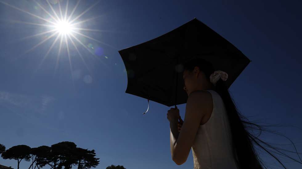 epa13080730 A woman shelters from the sun under an umbrella at Cap d'Antibes, southern France, 02 July 2026. Temperatures in Antibes reached up to 37 degrees Celcius as a spell of hot weather affected much of Europe.  EPA/SEBASTIEN NOGIER