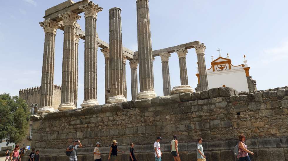 Turistas procuram a sombra ao visitar o Templo Romano, quando em Évora os termómetros ao final da manhã chegam aos 40 graus, 13 de julho de 2022. Devido a uma onda de calor em Portugal continental, que dura há vários dias, são esperadas temperaturas acima dos 45 graus em vários pontos do Alentejo e Ribatejo. NUNO VEIGA/LUSA