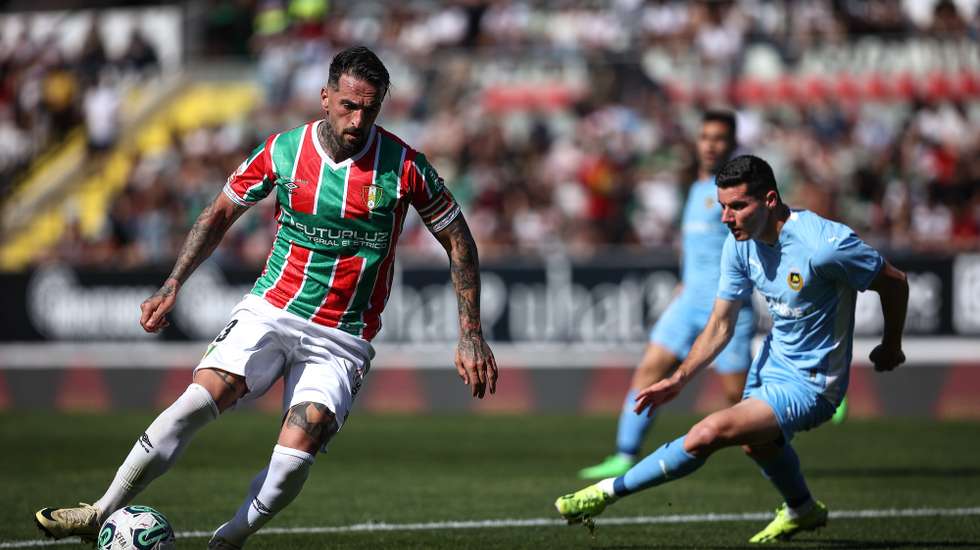 O jogador do Estrela da Amadora, Miguel Lopes (E), disputa a bola com o jogador do Rio Ave, Vrousai (D), durante o jogo da 29ª jornada da Primeira liga de futebol, disputado  no Estádio José Gomes em Lisboa, 14 de abril 2024. RODRIGO ANTUNES/LUSA