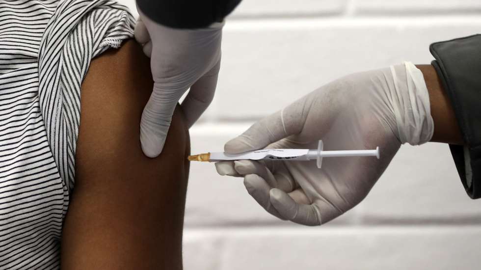 epa08556527 (FILE) - One of the first South African vaccine trialists gets injected during the clinical trial for a potential vaccine against the Covid-19 Corona virus at the Baragwanath hospital in Soweto, South Africa, 24 June 2020 (reissued 20 July 2020). Early phases of testing for a coronavirus vaccine suggest a positive result in immune reaction, scientists at Oxford University said 20 July 2020.  EPA/SIPHIWE SIBEKO / POOL *** Local Caption *** 56173130