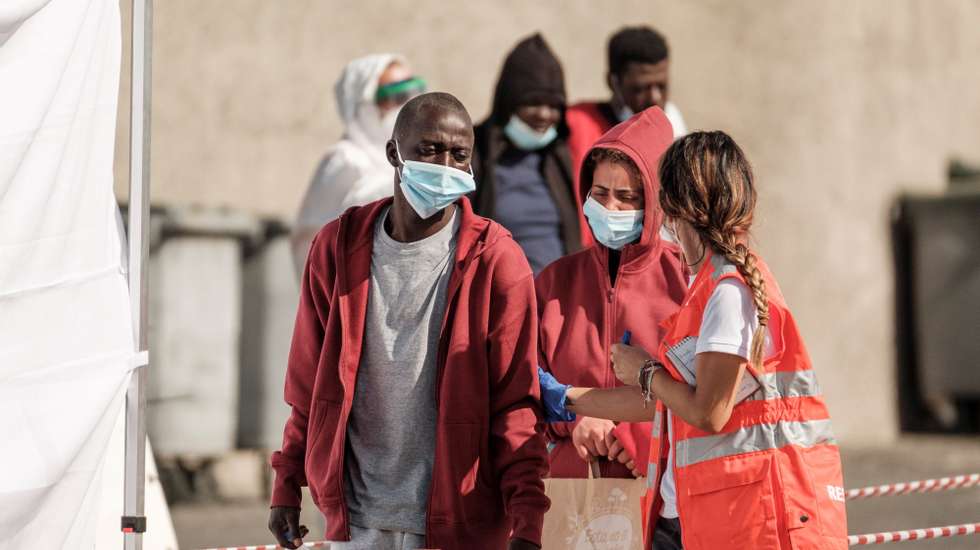 epa09247083 Members of the emergency services assist migrants as they arrive to Arguineguin Port in Gran Canaria, Spain, 04 June 2021. A total of 37 migrants that navigated on board a small boat were rescued at sea by Spanish Rescue Maritime Services, 203 km away from the coast.  EPA/Angel Medina G.