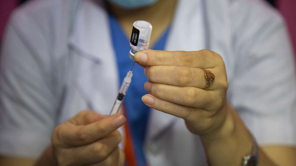 epa09343625 A health worker prepares a dose of Pfizer-BioNTech Covid-19 coronavirus vaccine for a Bangladeshi migrant worker at the Dhaka Medical Collage Hospital in Dhaka, Bangladesh, 14 July 2021. According to the Bangladesh health authorities, administering the Pfizer-BioNTech Covid-19 vaccines started at three hospitals in Dhaka.  EPA/MONIRUL ALAM