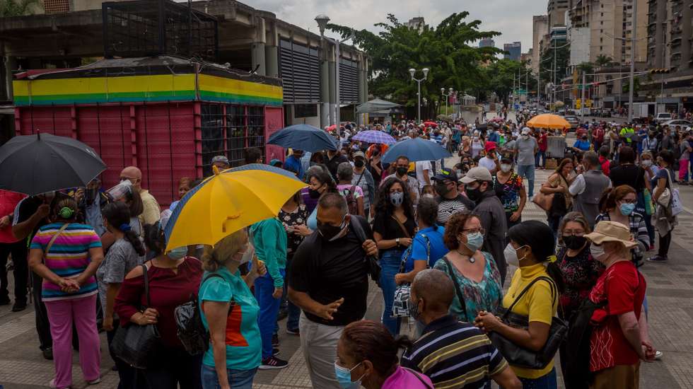 epa09249719 Dozens of people wait outside a COVID-19 vaccination center in Caracas, Venezuela, 02 June 2021 (Issued 05 June 2021). Hundreds of Venezuelans went this week to the vaccination points established by the government, waiting to be vaccinated. The system, which started in a 'controlled' way, became, with the passing of days, in disorder.  EPA/MIGUEL GUTIERREZ