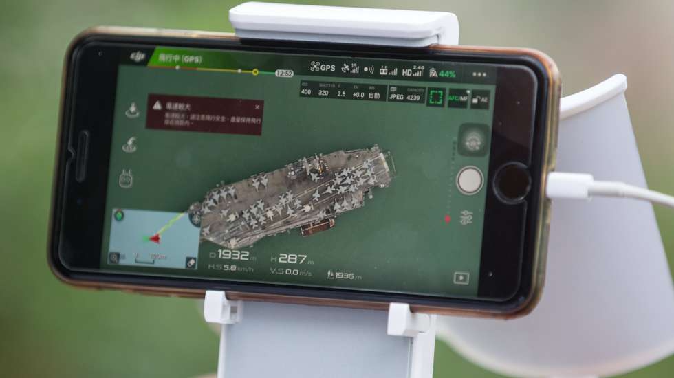epa06247192 A man takes photos with a drone of the aircraft carrier USS Ronald Reagan berthed in Hong Kong, China, 06 October 2017. The USS Reagan arrived in Hong Kong on 02 October as South Korean media reported that the vessel would take part in a joint exercise with the South Korean navy around 15 October.  EPA/JEROME FAVRE