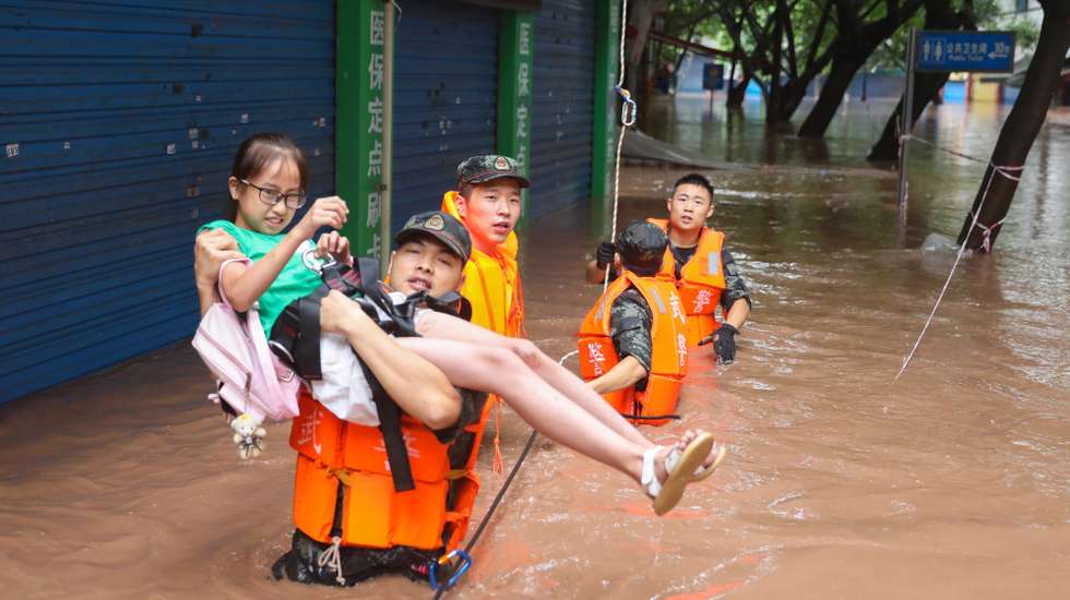 epaselect epa08551608 Paramilitary policemen evacuate residents in a flooded residential area in Wanzhou in southwest China's Chongqing Municipality, China, 16 July 2020 (issued 17 July 2020). The floodings in July have affected over 20 million people in China, causing 23 deaths or missings.  EPA/ZOU MOU CHINA OUT