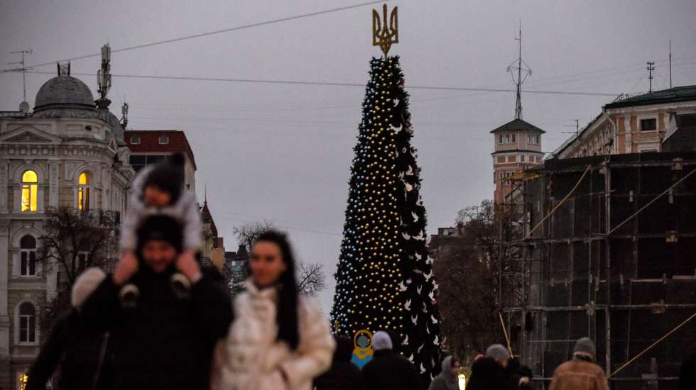 epa10372639 People take pictures and walk by a Christmas tree installed at Sofiyska Square, in Kyiv, Ukraine, 18 December 2022. Russian troops entered Ukraine on 24 February resulting in fighting and destruction in the country and triggering a series of severe economic sanctions on Russia by Western countries.  EPA/OLEG PETRASYUK