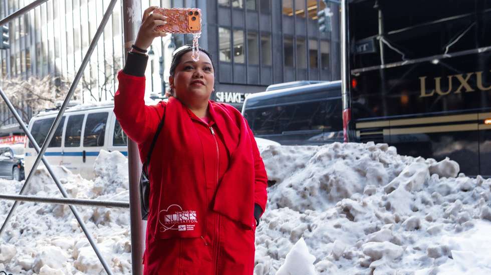 epa12700776 A nurse takes a photograph while marching to New York Governor Kathy Hochul's office as the strike continues in New York, New York, 02 February 2026. Nearly 15,000 nurses at major hospital systems—specifically Mount Sinai Hospital, Montefiore Medical Center, and NewYork-Presbyterian— have been on strike since 12 January, marking it as the largest nurses' strike in the city's history.  EPA/OLGA FEDOROVA