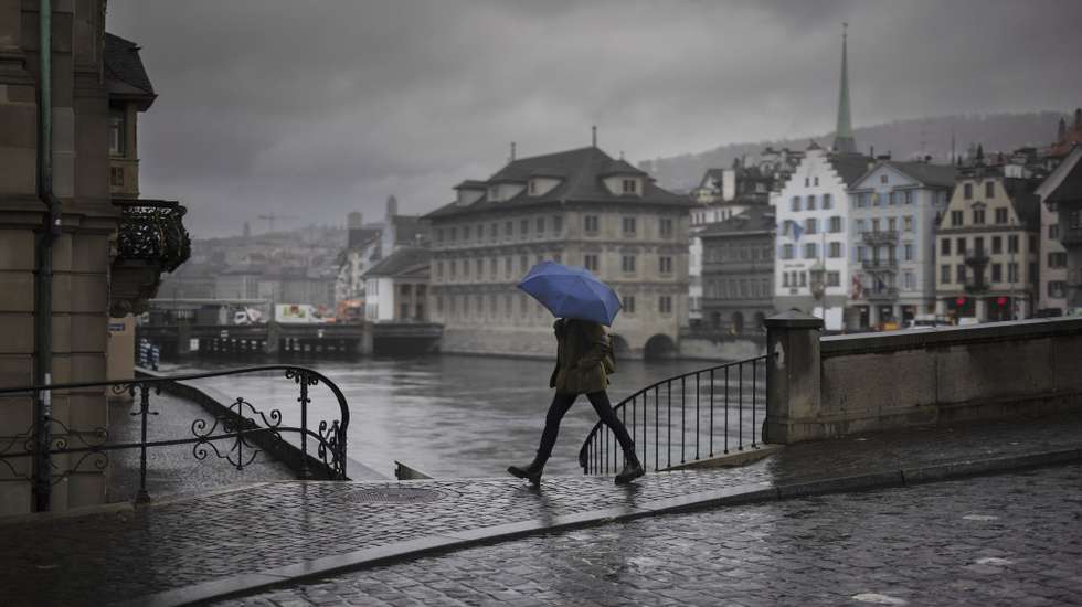 epa10987303 A woman crosses Muensterbridge over the river Limmat, on an autumnal day in Zurich, Switzerland, 21 November 2023.  EPA/MICHAEL BUHOLZER