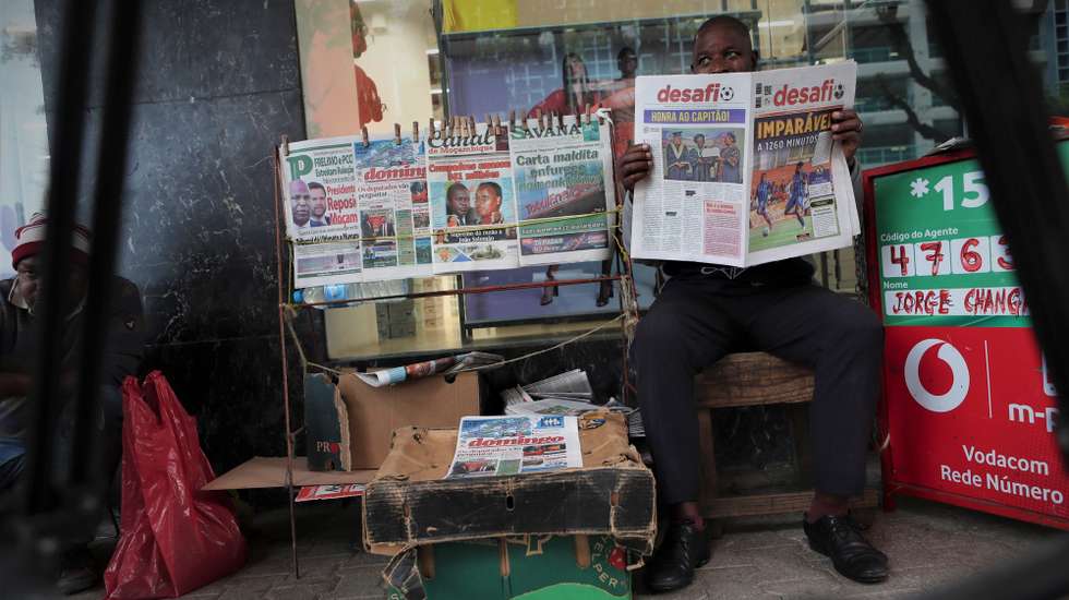 Um ardina lê um jornal enquanto espera por clientes, em Maputo, Moçambique, 03 de novembro de 2025. Ardinas de Maputo, na capital moçambicana, viram a venda de jornais a “baixar” depois da pandemia da covid-19, com a internet a “matar o negócio”, chegando a passar um dia sem vender um exemplar. (ACOMPANHA TEXTO DA LUSA DE 10 DE NOVEMBRO DE 2025). LUÍSA NHANTUMBO/LUSA
