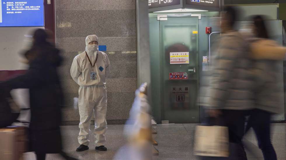 epa08972525 A member of security checks travellers at a railway station in Shanghai, China, 29 January 2021. Chinese New Year is the period of the world’s largest annual human migration. Hundreds of millions of people travel back to their hometowns to celebrate and spend time with their families. In recent weeks China has seen small outbreaks of locally transmitted COVID-19 cases. According to China's National Health Commission, people who are going back home need to have a negative COVID-19 test issued up to seven days before departure, 14 days quarantine time, or home observation and testing every seven days.  EPA/ALEX PLAVEVSKI