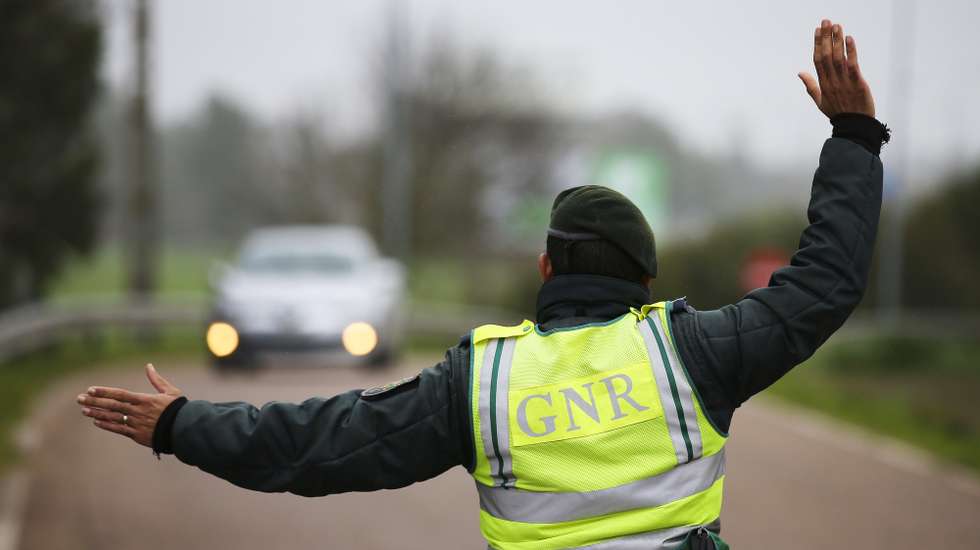 epa08977052 A Portuguese Republican National Guard (GNR) agent orders a vehicle to stop during a control operation at the entrance to Portugal through the border of Caia (Elvas), Portugal, 31 January 2021. Spain and Portugal have re-established the border controls until 10 February, a period during which only the entry of residents or students, will be allowed or for work-realted reasons or to visit marriage partners.  EPA/NUNO VEIGA