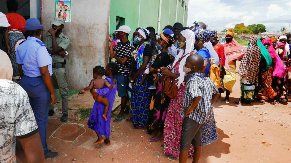 epa09112040 Displaced people outside the temporary shelter centre in Pemba, Mozambique, 02 April 2021. Mixed with laughter and banter, they are a contrast to the deadly attack by Islamic State-linked insurgents in northern Mozambique, that the about 200 people sheltering there have experienced in the last week.  EPA/LUIS MIGUEL FONSECA