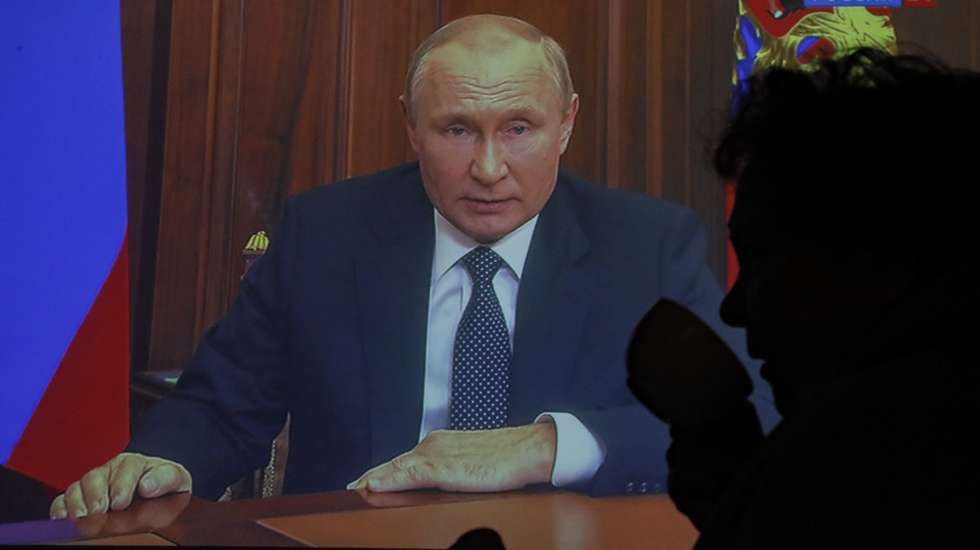 epa10196253 Lidia, a 75-year-old refugee from Mariupol, drinks morning tea as she is silhouetted against a TV screen displaying Russian President Vladimir Putin during a televised address to the nation, in Moscow, Russia, 21 September 2022. President Putin hasÂ signed a decreeÂ on partial mobilization in the Russian Federation, with mobilization activities starting on 21 September. Russian citizens who are in the reserve will be called up for military service.  EPA/SERGEI ILNITSKY