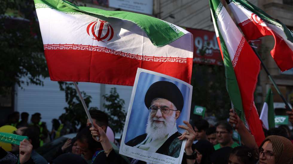 epa12175390 An Iranian woman holds a poster of Iranian supreme leader Ayatollah Ali Khamenei during an anti-Israel rally in Tehran, Iran, 14 June 2025. Israel confirms it has launched strikes on Iran's 'nuclear program' as blasts are heard across the country. Israel launched strikes on Iran's nuclear and military facilities on 13 June, targeting top generals and scientists. In retaliation, Iran launched waves of missiles and drones toward Israel.  EPA/ABEDIN TAHERKENAREH