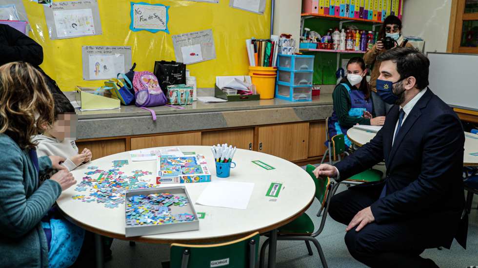 O ministro da Educação, Tiago Brandão Rodrigues (D), conversa com um aluno, durante a visita à Escola EB1/JI (n.º 3) de São Brás de Alportel, José Belchior Viegas,  uma das mais 700 escolas de referencia que, por todo o país, dão resposta a filhos e outros dependentes dos trabalhadores de serviços essenciais, prestam apoios terapêuticos a alunos com necessidades educativas especificas e servem refeições aos alunos abrangidos pela ação social escolar, em São Brás de Alportel, 08 de fevereiro de 2021. LUÍS FORRA/LUSA