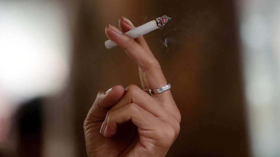 epa10379028 A man smokes a cigarette at a street in Jakarta, Indonesia, 27 December 2022. Indonesian President Joko Widodo has issued Presidential Decree of the Republic of Indonesia concerning the 202 government regulation drafting program, one of them is to stipulate a ban on the sale of cigarette sticks, on the restriction of addictive substances in tobacco products for health.  EPA/ADI WEDA