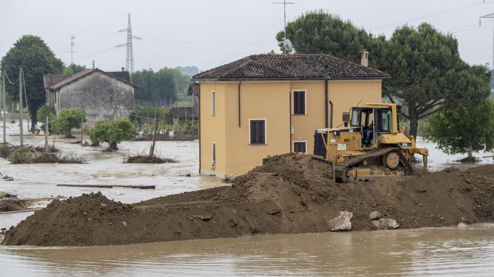 epa10641403 An excavator tries to rebuild embankment of the Sillaro river after it broke the embankment, destroying a house and flooded the town in attempt to block the water that is flooding the surrounding countryside, in Lugo, Emilia-Romagna region, Italy, 20 May 2023.  The death toll from this week's deadly flooding in Emilia Romagna has climbed to 14. The northeastern region will remain on red alert on 20 May with more rain forecast. Among other things, the risk of landslides is considered particularly high. The number of people who have had to leave their homes because of the flooding in Emilia-Romagna has risen to over 15,000, the regional government said on 19 May.  EPA/BOVE-ZANI