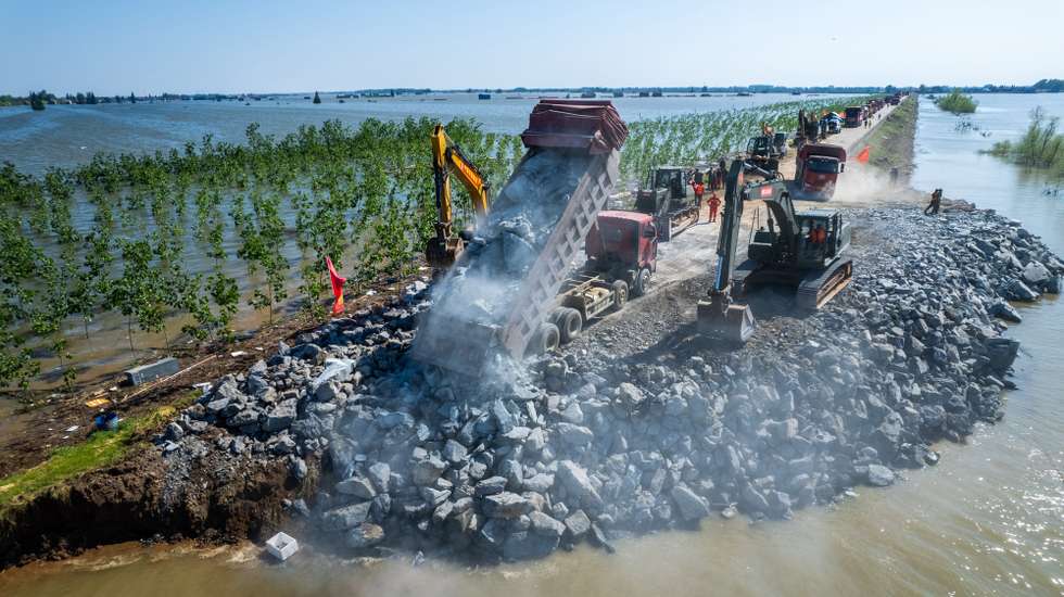 epa11462240 An aerial view taken with a drone shows rescuers blocking a dike breach of Dongting Lake in Tuanzhou Township, Huarong County under Yueyang City, central China's Hunan Province, 06 July 2024. A work team has been dispatched to central China's Hunan Province to guide rescue efforts after a dike breach in the country's second-largest freshwater lake on 06 July afternoon, according to the Ministry of Emergency Management. More than 800 people from the China National Comprehensive Fire and Rescue Team, 146 vehicles and 82 boats have been sent to the scene, according to the ministry.  EPA/XINHUA / CHEN SIHAN CHINA OUT / UK AND IRELAND OUT  /       MANDATORY CREDIT EDITORIAL USE ONLY
