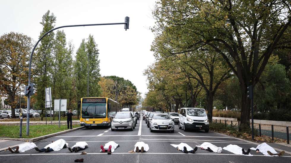 Passadeira com pessoas cobertas de lençóis brancos, numa evocação das vidas humanas que injustamente se perdem todos os anos, iniciativa integra o Dia Mundial em Memória das Vítimas das Estradas, organizada pela MUBi e Estrada Viva, em Lisboa, 18 de novembro de 2023. RODRIGO ANTUNES/LUSA