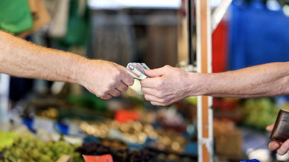 epa10843379 A customer pays for their purchase at a weekly market, in Essen, Germany, 06 September 2023. According to German government's statistics, food prices in July 2023 were on average 11 percent higher compared to the same period in 2022. German welfare organizations reported in 2022 that 13.8 million people in Germany lived in poverty or were at risk of being below the poverty line.  EPA/CHRISTOPHER NEUNDORF