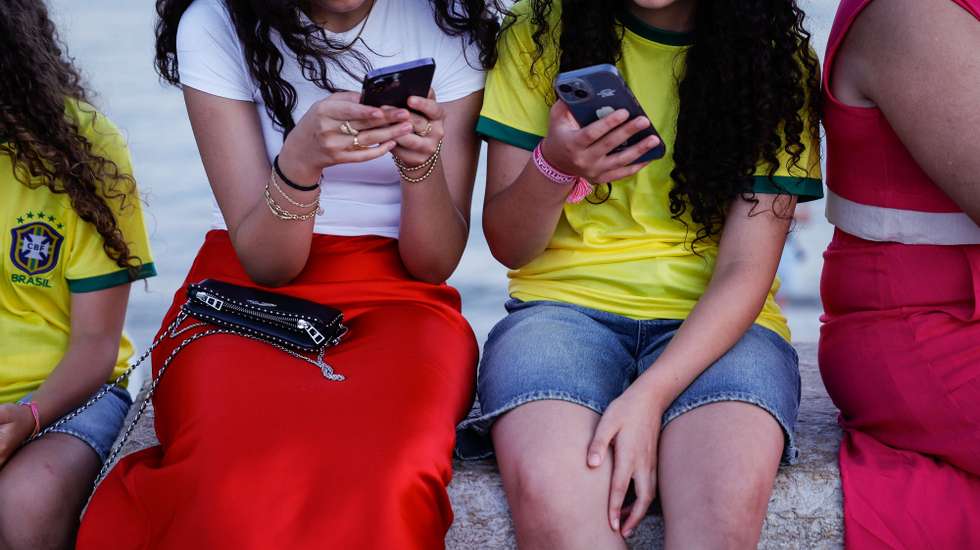 Duas jovens consultam o telemóvel, em Lisboa, 07 de agosto de 2024. Adolescência. Comunicações. Internet. ANTÓNIO PEDRO SANTOS/LUSA