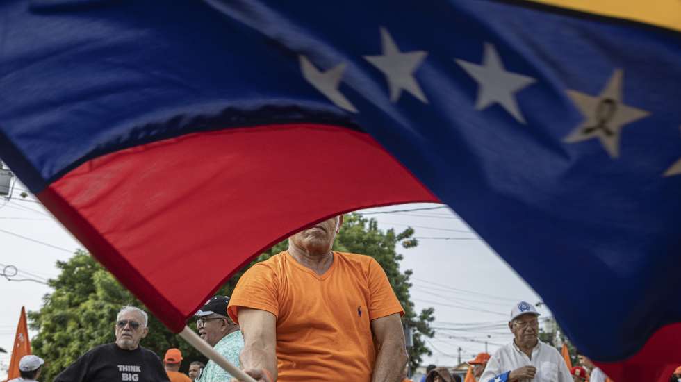 epaselect epa13006059 A person waves a Venezuelan flag at a demonstration in Maracaibo, Venezuela, 30 May 2026. More than a thousand Venezuelans, along with several of the country’s leading opposition figures, gathered in Maracaibo, the capital of Zulia state to demand the holding of presidential elections and the release of all political prisoners.  EPA/Henry Chirinos