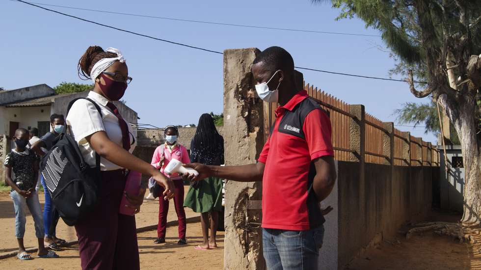 epa09090135 A student has her temperature taken at the entrance of a school on the first day back to school due to covid-19 related closure, in Maputo, Mozambique, 22 March 2021. Mozambique lived in a state of emergency between April and September 2020, and since then the state of calamity has been in effect, a legal designation to frame several restrictions aimed at preventing covid-19, which included the suspension of classes.  EPA/LUISA NHANTUMBO