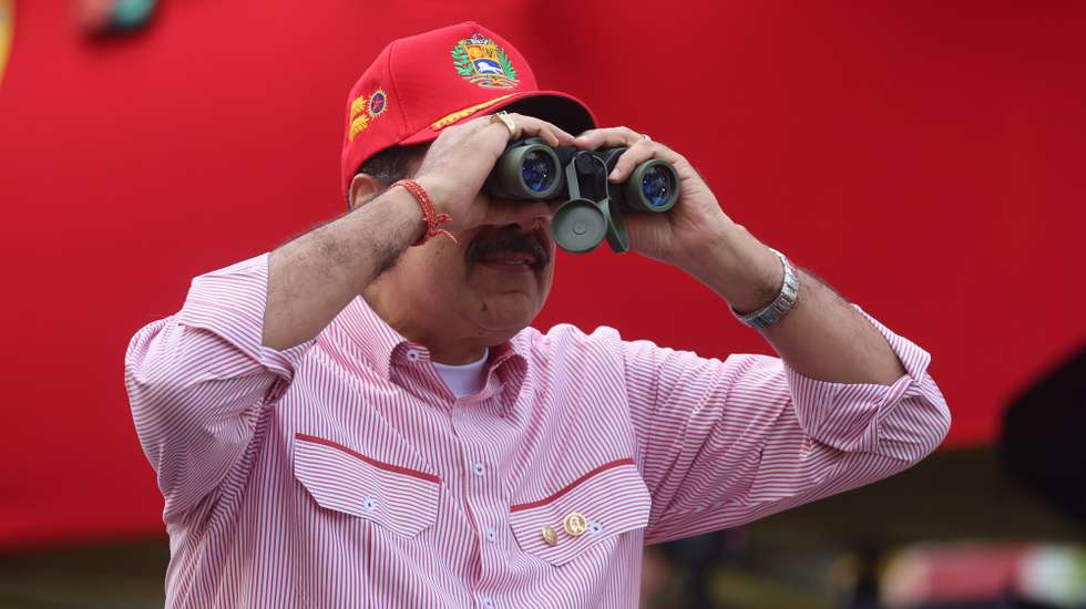 epa12563447 Venezuelan President Nicolas Maduro looks through binoculars during a rally in Caracas, Venezuela, 01 December 2025. Chavistas said they seek peace but are prepared to 'defend the homeland' during a rally to swear in the so-called Bolivarian Integral Commands amid tensions over the US military deployment in the Caribbean.  EPA/Miguel Gutierrez
