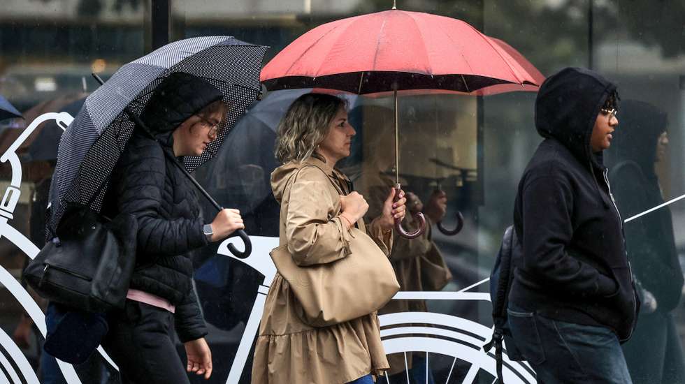 Pessoas abrigam-se da chuva junto ao Hospital São João, no Porto, 24 de setembro de 2024. De acordo com o Instituto Português do Mar e da Atmosfera (IPMA), prevê-se a ocorrência de períodos de chuva persistente a partir de hoje nas regiões Norte e Centro e que será por vezes forte na quarta e quinta-feira. ESTELA SILVA/LUSA