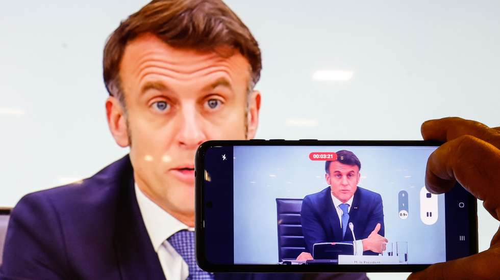 epa11894163 A man takes a photograph of a screen showing French President Emmanuel Macron as he speaks during the International Conference on Syria at the Ministerial Conference Center, in Paris, France, 13 February 2025  EPA/MOHAMMED BADRA