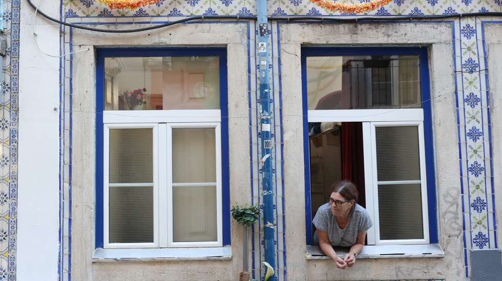 Uma mulher à janela num prédio no Baiiro Alto, em Lisboa