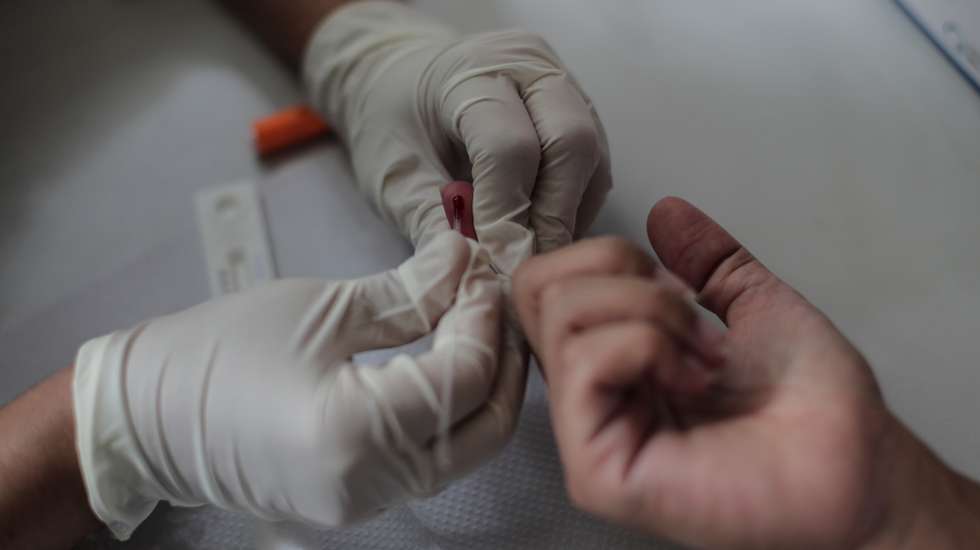 epa09022732 A woman performs a blood test for the diagnosis of COVID-19 at a health post in Rio de Janeiro, Brazil, 18 February 2021. Brazil, one of the countries hardest hit by the coronavirus pandemic along with the United States and India, on 18 February 2021 reached 243,457 deaths and 10,030,626 accumulated cases since the first contagion was registered, almost a year ago.  EPA/Antonio Lacerda