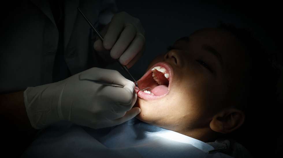 Uma dentista durante um tratamento a um rapaz na clínica “O Sol” que oferece tratamento dentário gratuito a crianças até aos 18 anos, Lisboa, 19 de março de 2025. A 20 de Março comemora-se o Dia Mundial da Saúde Oral.  (ACOMPANHA TEXTO DE 20-03-2025) ANTÓNIO PEDRO SANTOS/LUSA